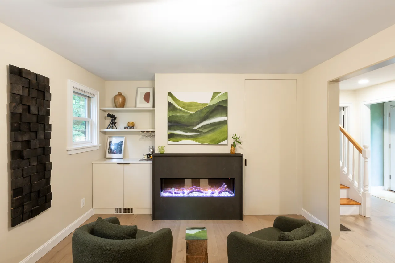 Living room with a fireplace and green chairs