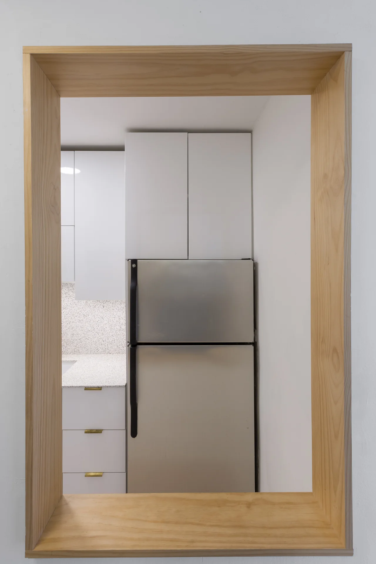 Compact kitchen viewed through a timber-trimmed doorway