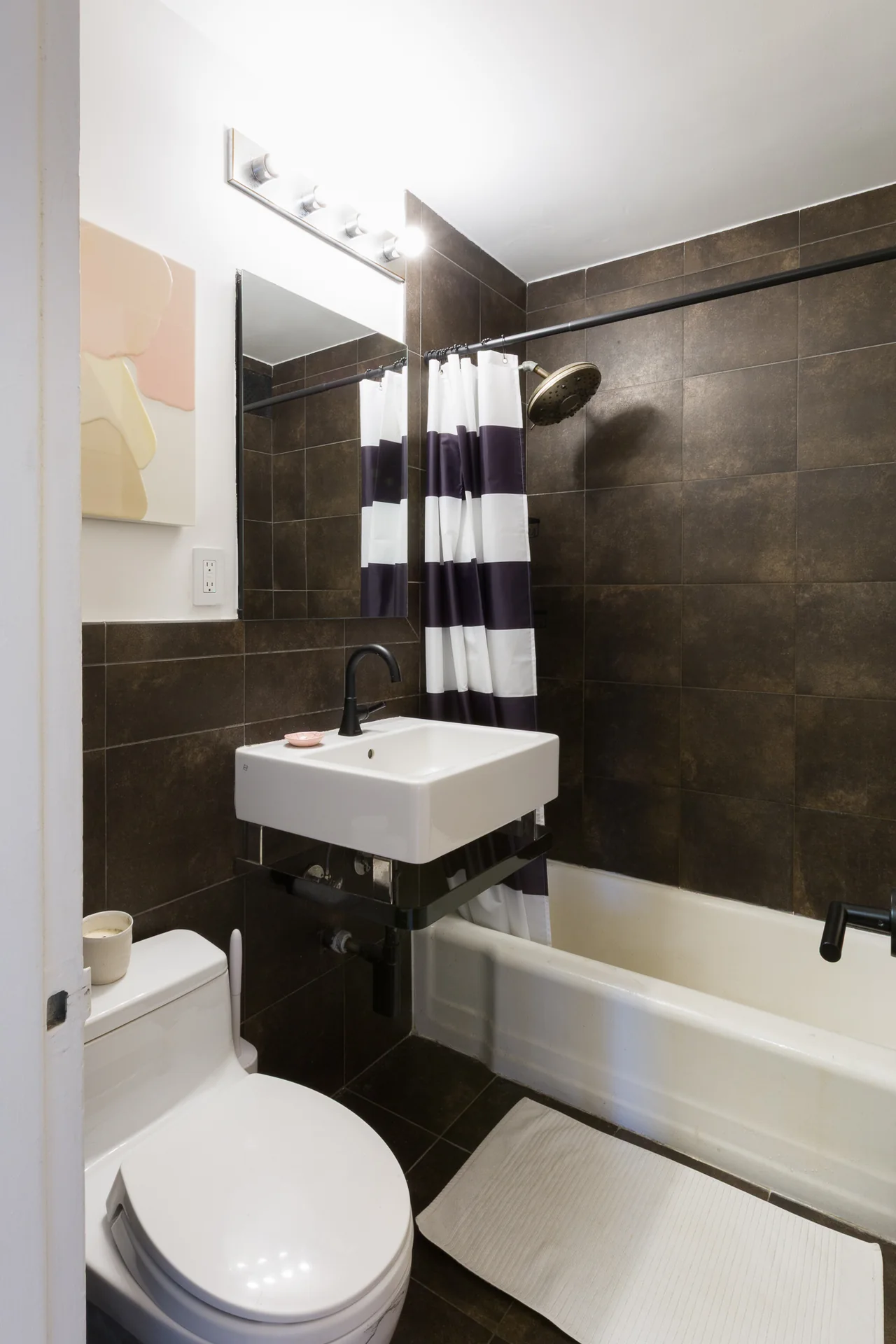 Bathroom with dark wall tiles and a white basin